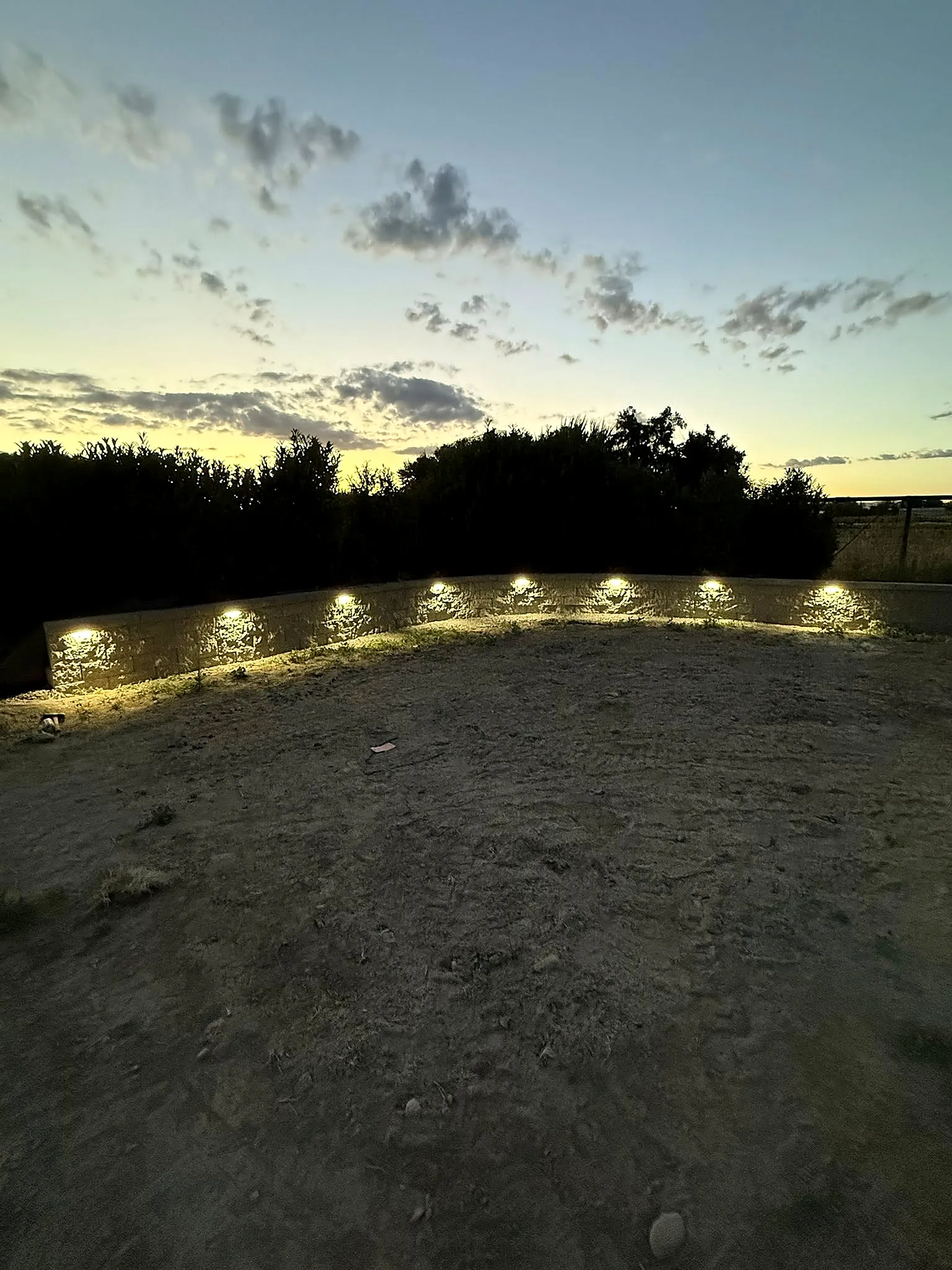 A retaining wall with integrated landscape lighting glowing at dusk