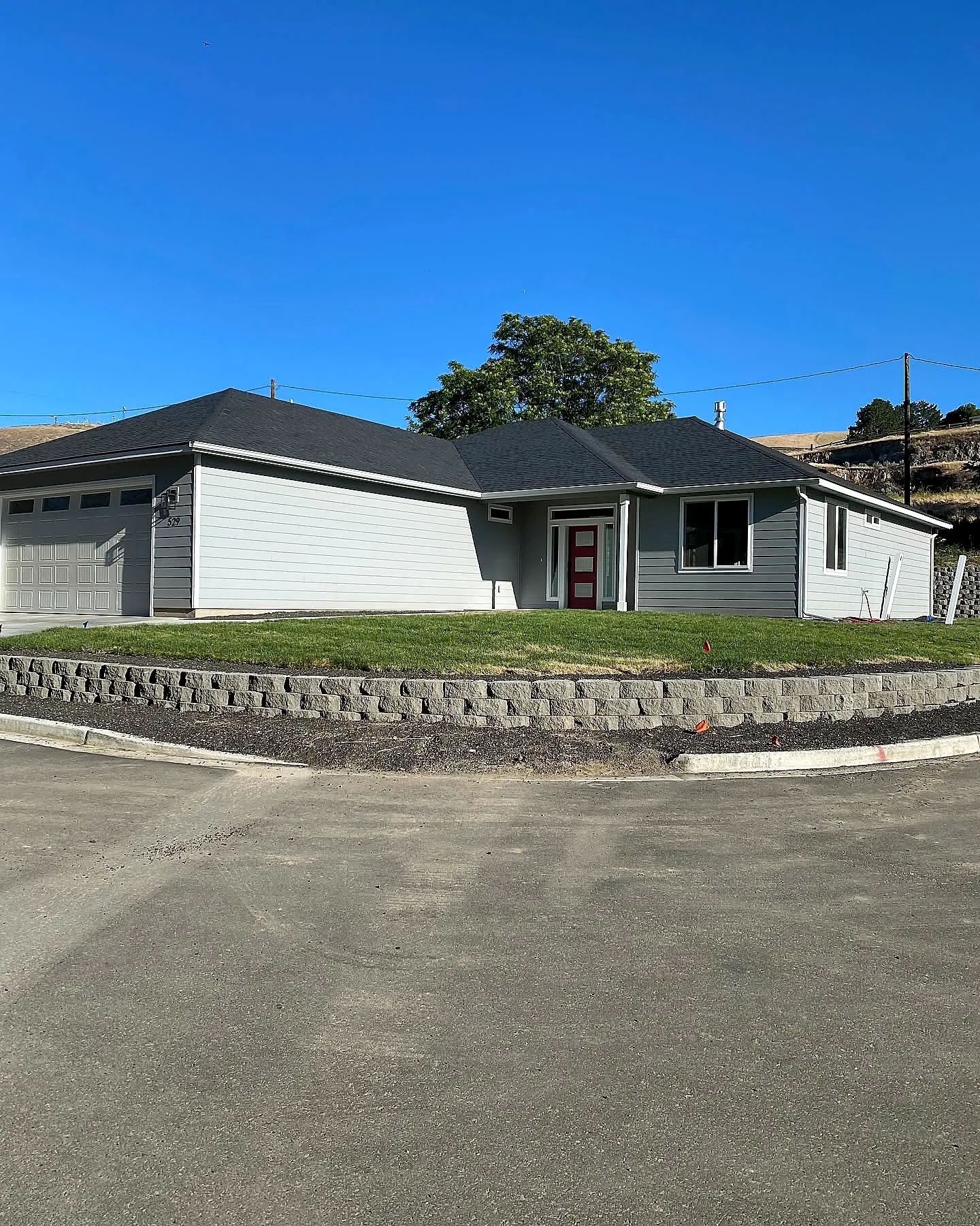 A Lower Yakima Valley home with a freshly mowed lawn and a tidy stone retaining wall — boosted curb appeal